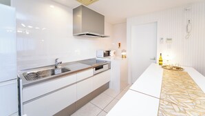 Een moderne keuken met een roestvrijstalen spoelbak, een magnetron en een inbouwoven.