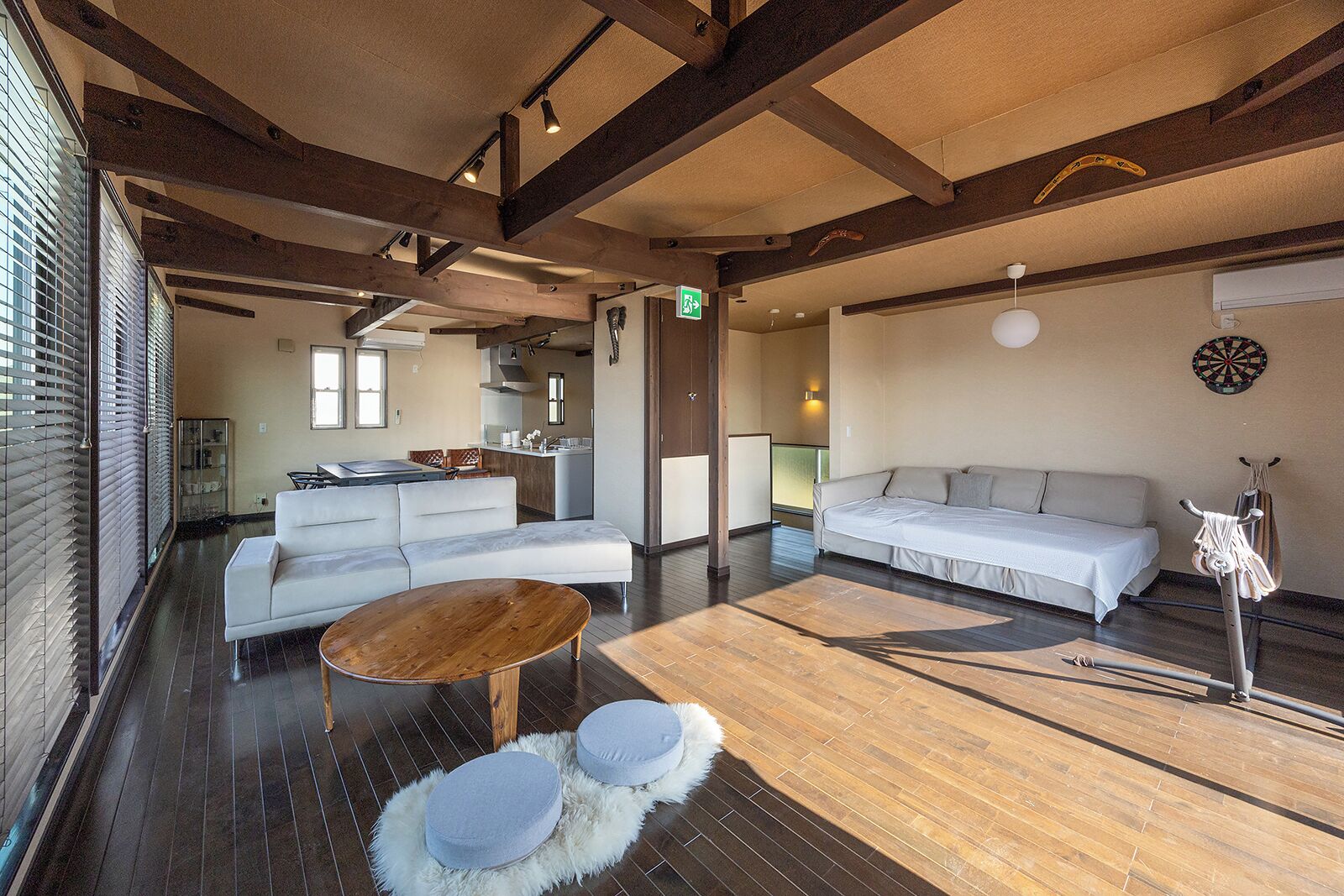 A modern interior with a sofa, a wooden coffee table, and a dining area.