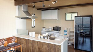 Una cocina moderna con una isla central, armarios blancos y un microondas integrado.