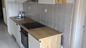 Eine Küche mit Holzarbeitsplatte, integriertem Backofen und Spüle.