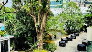 A courtyard with a central water feature, surrounded by lush greenery and outdoor seating. - Luxury Sea View 3 Bedroom AC Apartment 5 star hotel access and all amenities (Colombo)