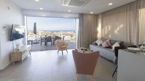 A modern living room with a sofa, a dining table, and a TV mounted on the wall. - Protaras Holiday Villa DS112 (Protaras)