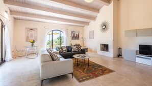 A spacious living room with a high ceiling, a fireplace, a sofa set, a coffee table, and a TV. - Awesome home in Trequanda with house a panoramic view (Trequanda)