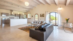 A spacious living area with a sofa, a coffee table, and a kitchen in the background. - Awesome home in Trequanda with house a panoramic view (Trequanda)