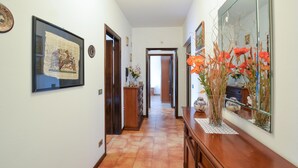 A hallway with a wooden dresser, a mirror, and a framed picture on the wall.