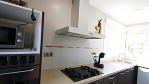 Une cuisine moderne équipée d’un four à micro-ondes, d’une cuisinière et d’un évier.
