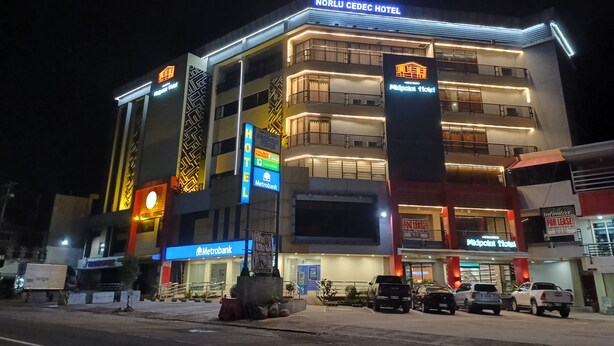 Hotellissa on moderni ulkoasu, ja sen edessä on suuri, näkyvästi sijoitettu kyltti, jossa lukee »Norlu Cedeh Hotel», sekä toinen kyltti, jossa lukee »Midpoint Hotel». Hotellin edessä näkyy myös Metrobankin toimipiste.
