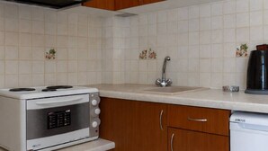 Cozinha com forno branco, pia e armários de madeira.