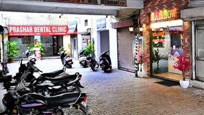 Ein Hotel namens 'Rainbow' mit Schildern für 'Embassy Hotel Restaurant' und 'Prashar Dental Clinic'.