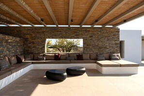 Un espace extérieur aménagé avec des murs en pierre, un plafond en bois et une vue sur le paysage.