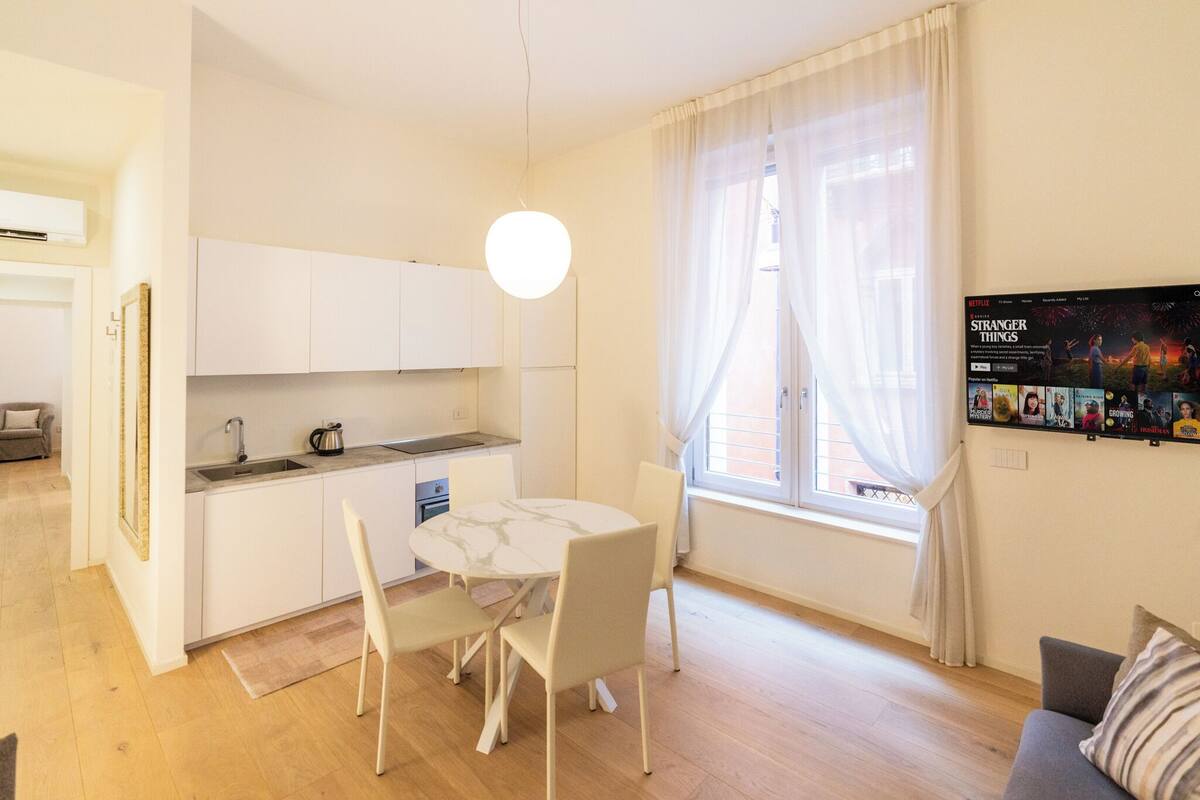 A modern apartment with a kitchen, dining area, and living room.