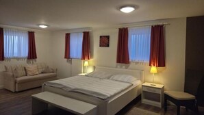 A bedroom with a bed, bedside tables, a nightstand, a chair, and a sofa. - Plenty of space for the whole family - North Sea vacation at Haus Küstenwind - House (Wyk auf Föhr)