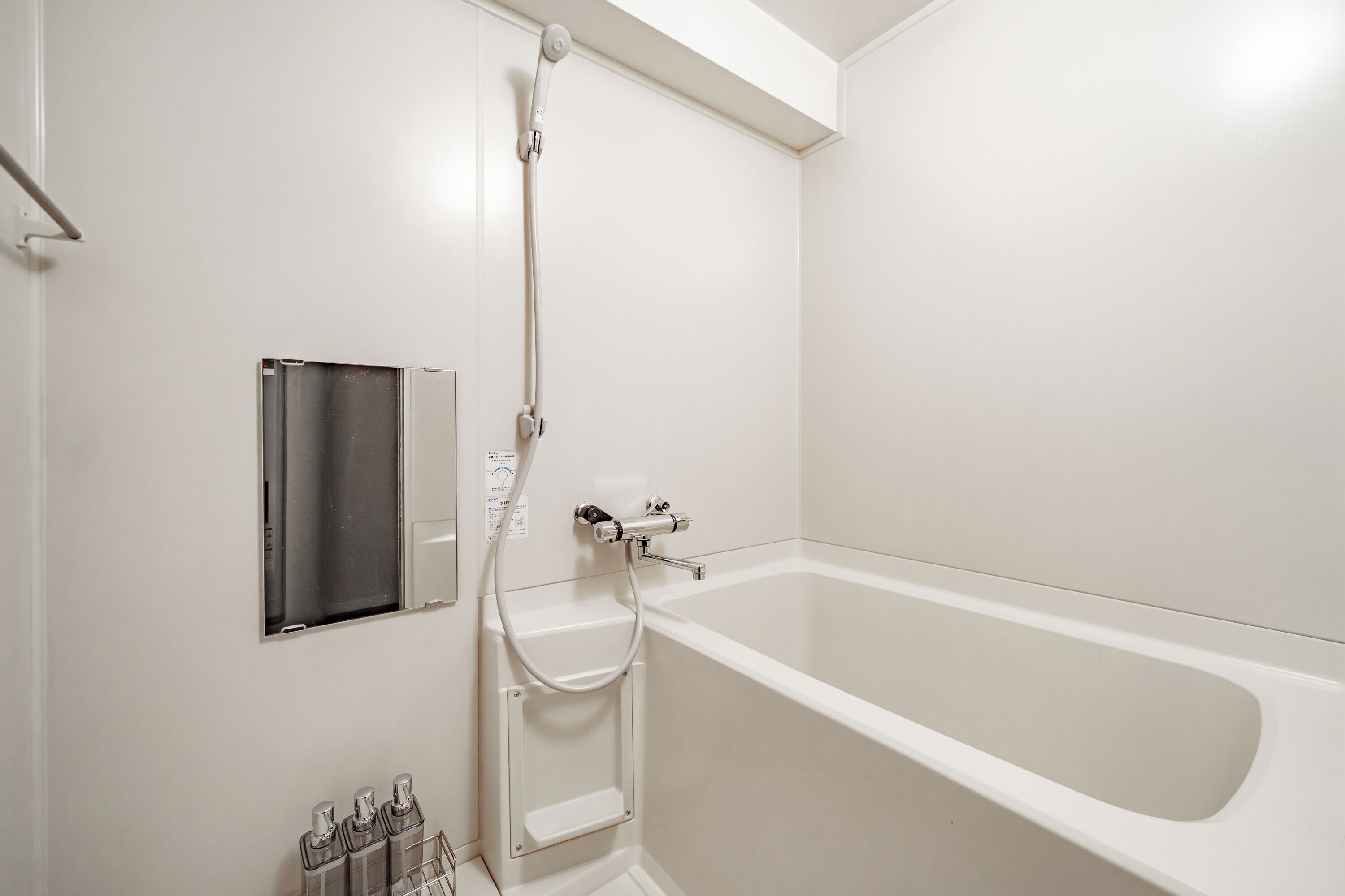 A modern bathroom with a bathtub, a shower, and a built-in medicine cabinet.