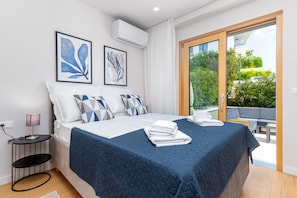 Un dormitorio moderno con una cama grande, una mesita de noche y vistas al exterior.
