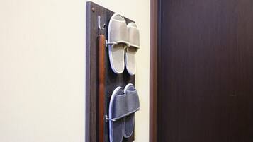 A wall-mounted shoe rack with two pairs of shoes.