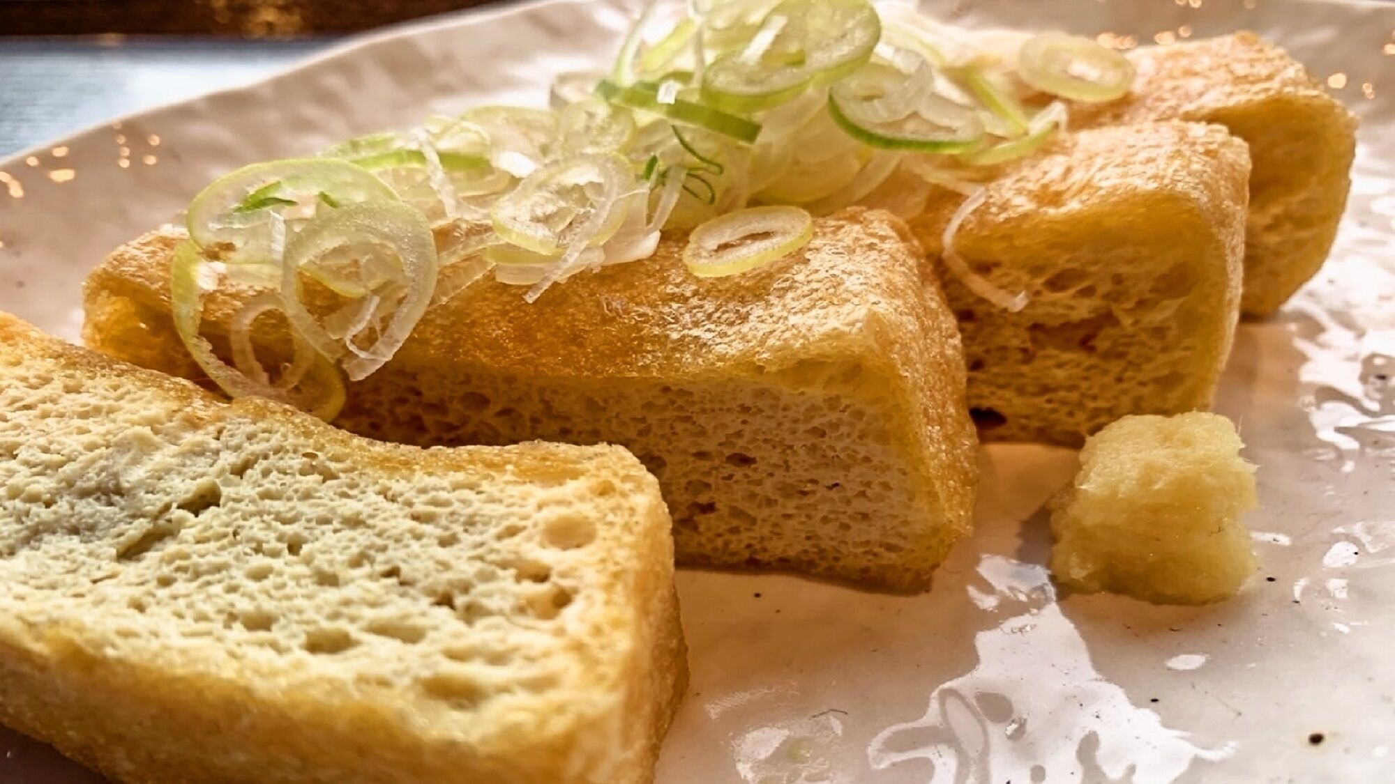A plate with bread and sliced green onions.