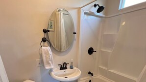 Un bagno compatto con il water, lavandino e vasca.