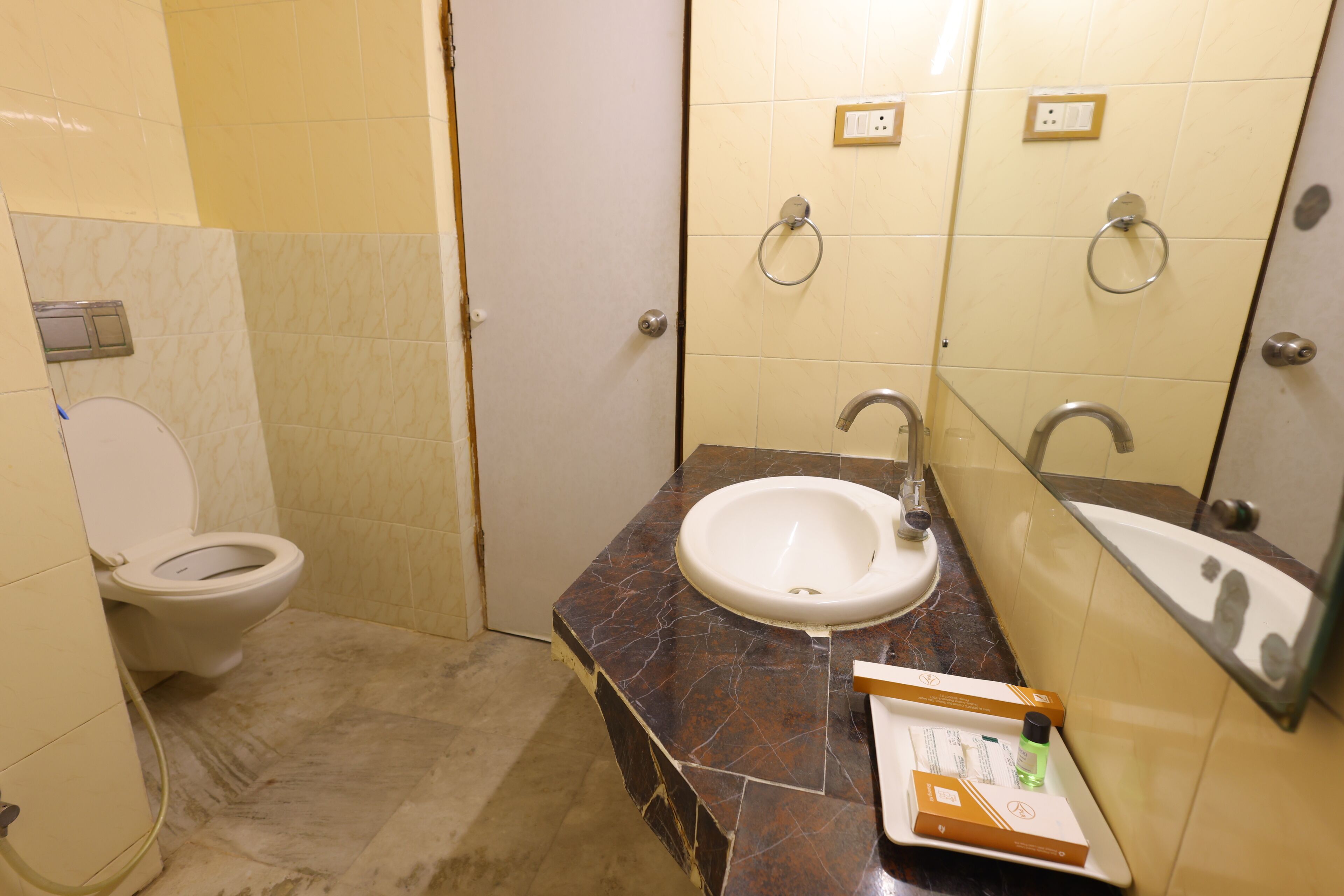 A bathroom with a toilet, sink, and mirror.