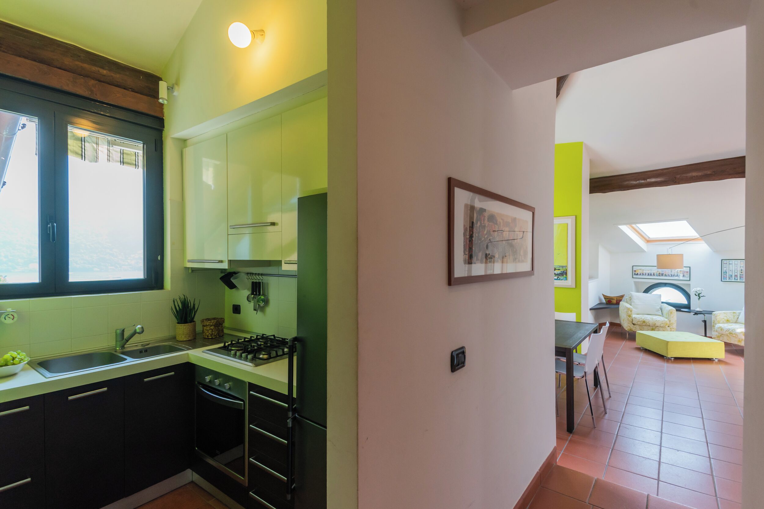Eine moderne Küche mit Fenster, Spüle und Herd. Ein Essbereich mit Tisch und Stühlen vorhanden.