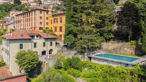 Un quartier résidentiel situé sur une colline, doté d’une piscine, de maisons en terrasses et d’une végétation luxuriante.
