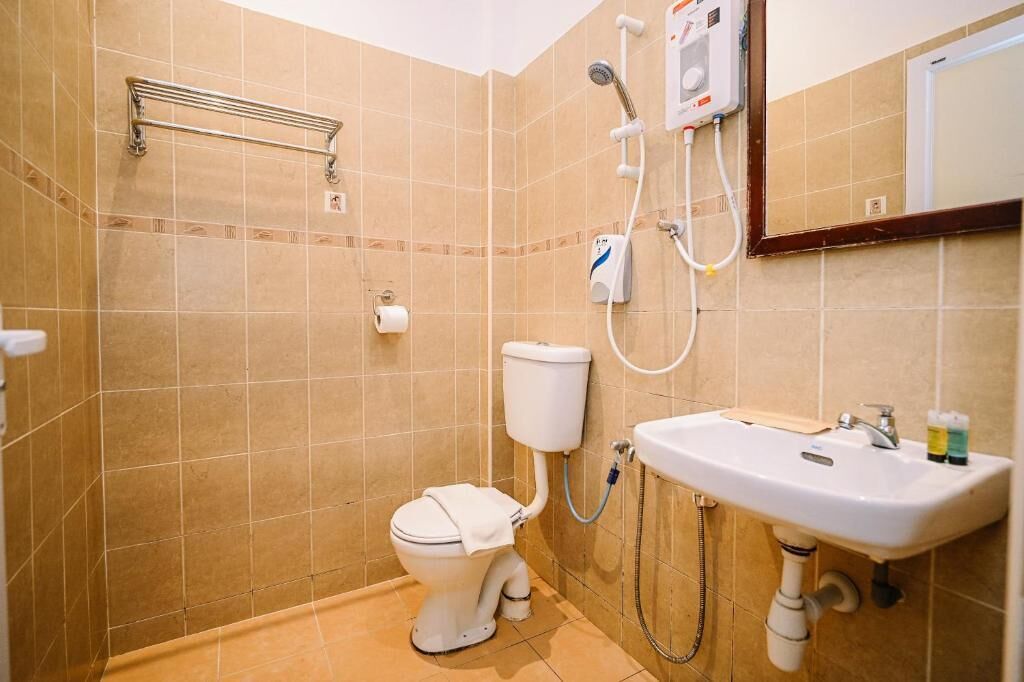 A bathroom with a toilet, a sink, a shower, and a towel rack.