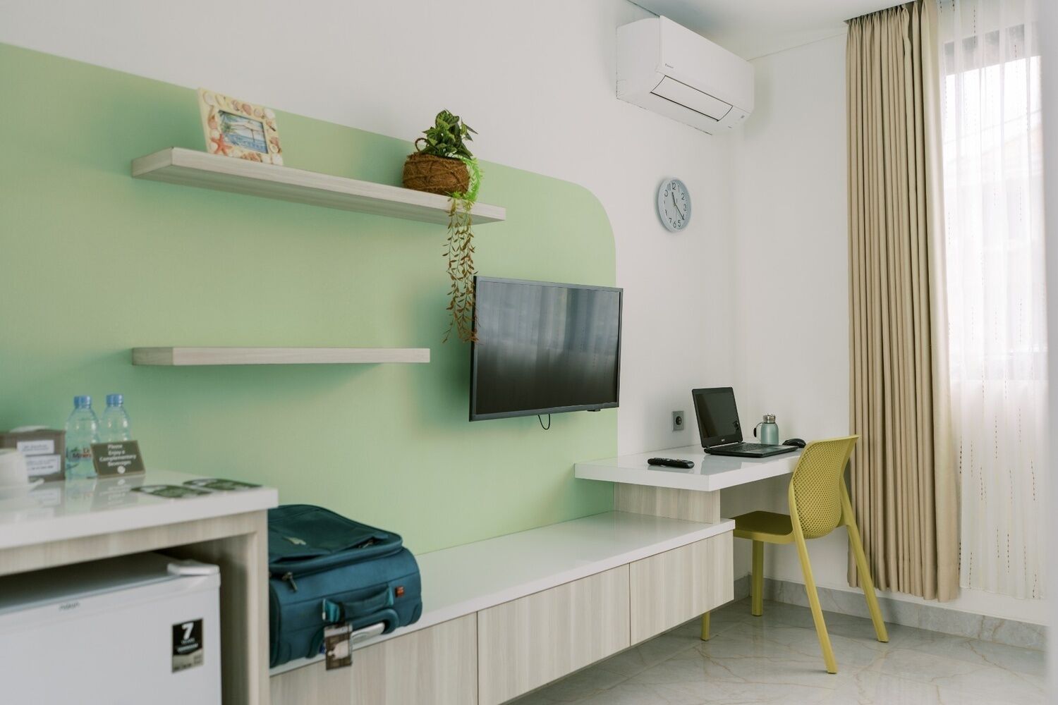 Une chambre d’hôtel équipée d’une télévision, d’un bureau, d’une chaise et d’un lit.