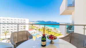 A balcony with wicker furniture, a table with a bottle of Moët & Chandon champagne, two glasses, and a bowl of strawberries. - Cala Millor, beautiful apartment, 6 floor, 2 bedrooms, sea view, directly at the beach WIFI (Sant Llorenç des Cardassar)