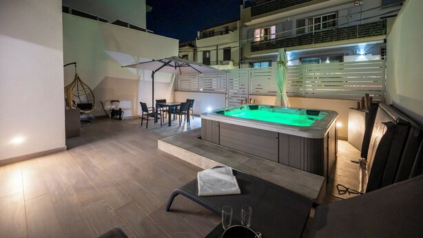 A rooftop pool area with a hot tub, seating, and a swing chair. - Mediterranea Suite (Avola)