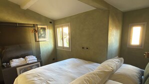 A bedroom with a large bed, a bedside table with a lamp, and a framed picture on the wall. - In Downtown Florence above Santa Croce, the most beautiful church, renovated 2026 (Firenze)