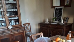 A dining table set with various breakfast items, including pastries, fruits, and a bottle of juice.