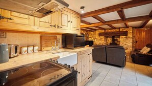 Eine Küche mit Holzausstattung, einem Einbauofen und einer Steinwand.