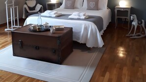 A bedroom with a bed, bedside tables, a dresser, a hanging light fixture, and a wooden ceiling. - Bed and Breakfast 'Chambre Lavande' with Shared Terrace, Shared Garden and Wi-Fi (Eaux-Puiseaux)