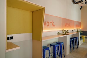 A modern workspace with a long counter, blue stools, and a wall with the word 'work.' - Homaris K48 Studios (Berlin)
