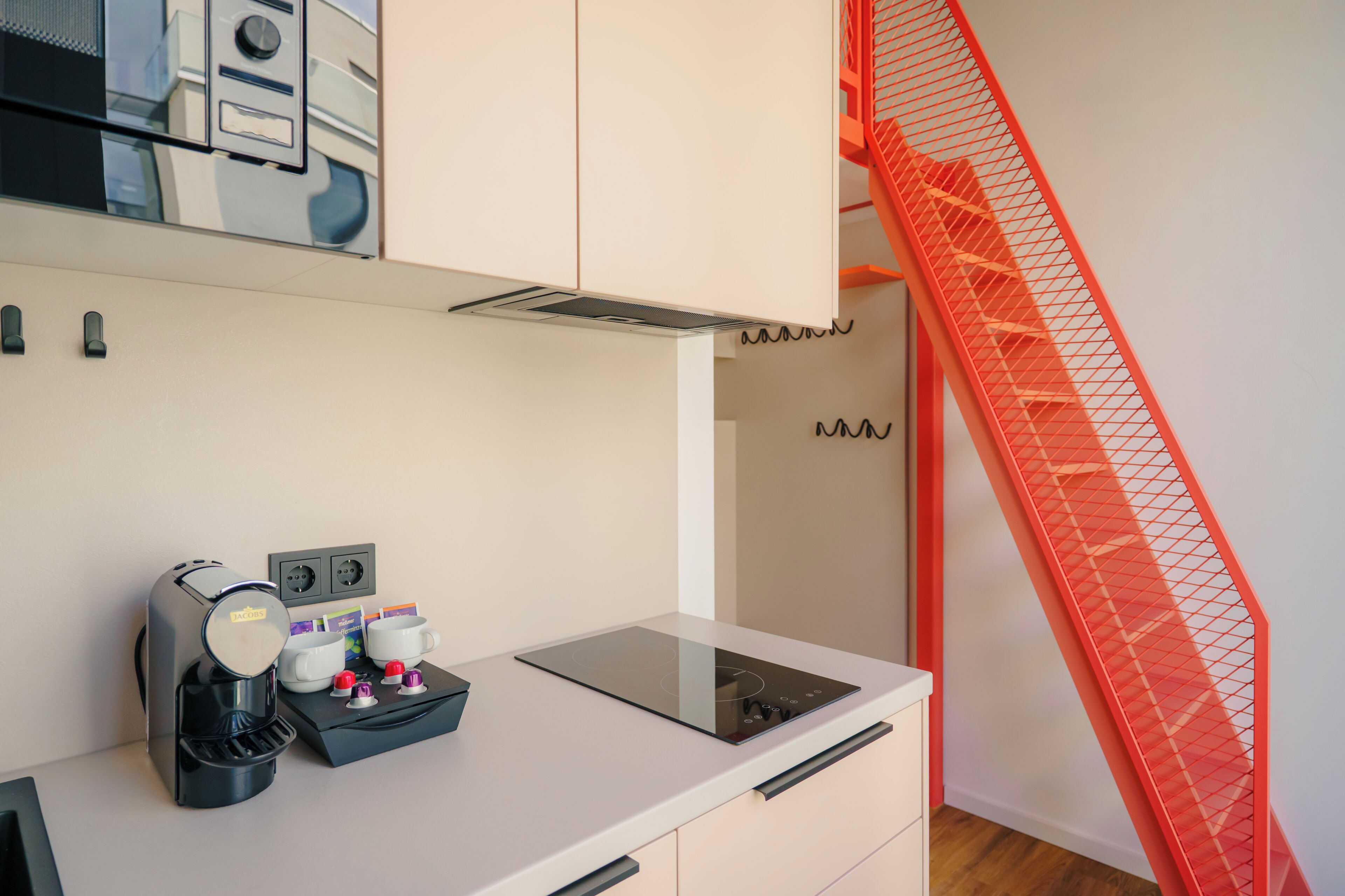 A kitchenette with a coffee maker, mugs, and a toaster.