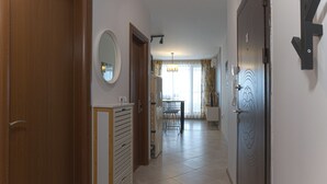 A hallway with a wooden door, a mirror, and a patterned door on the right. - Welcoming 1-bedroom apartment  in charming Sozopol (Sozopol)