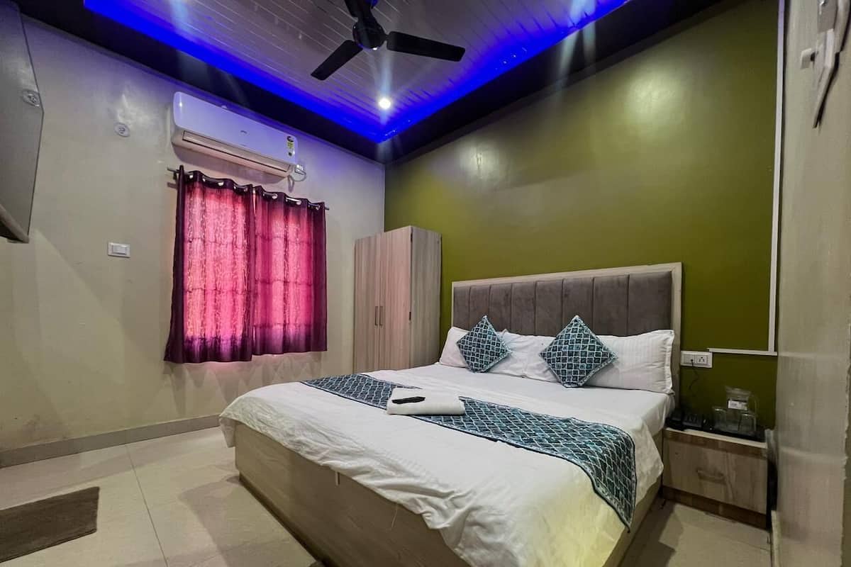 A bedroom with a bed, nightstand, and wardrobe.