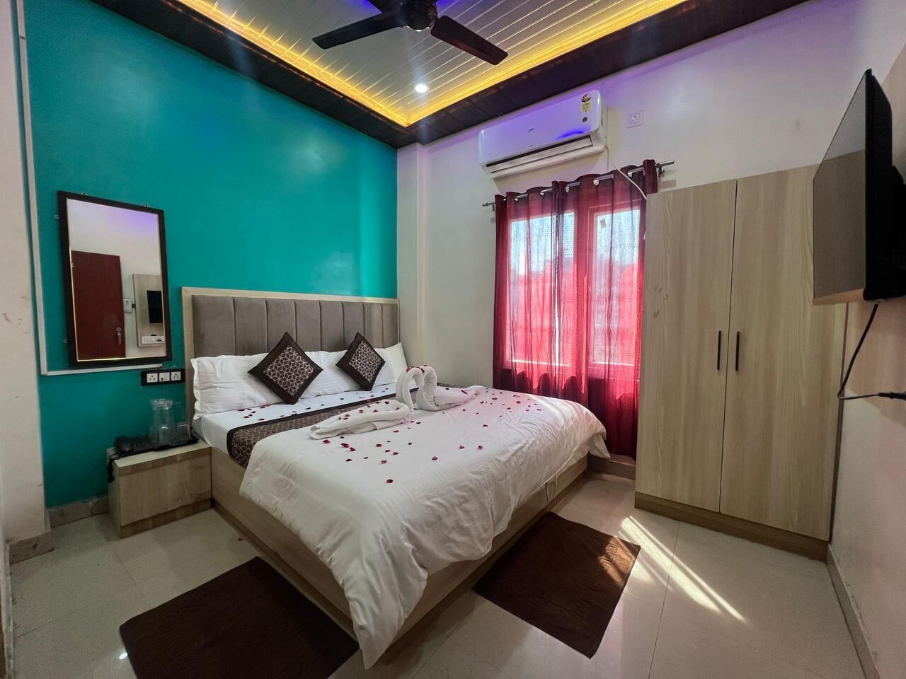 A bedroom with a bed, nightstands, a wardrobe, and an air conditioning unit.