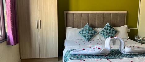A hotel room with a bed, a wardrobe, and a window with curtains.