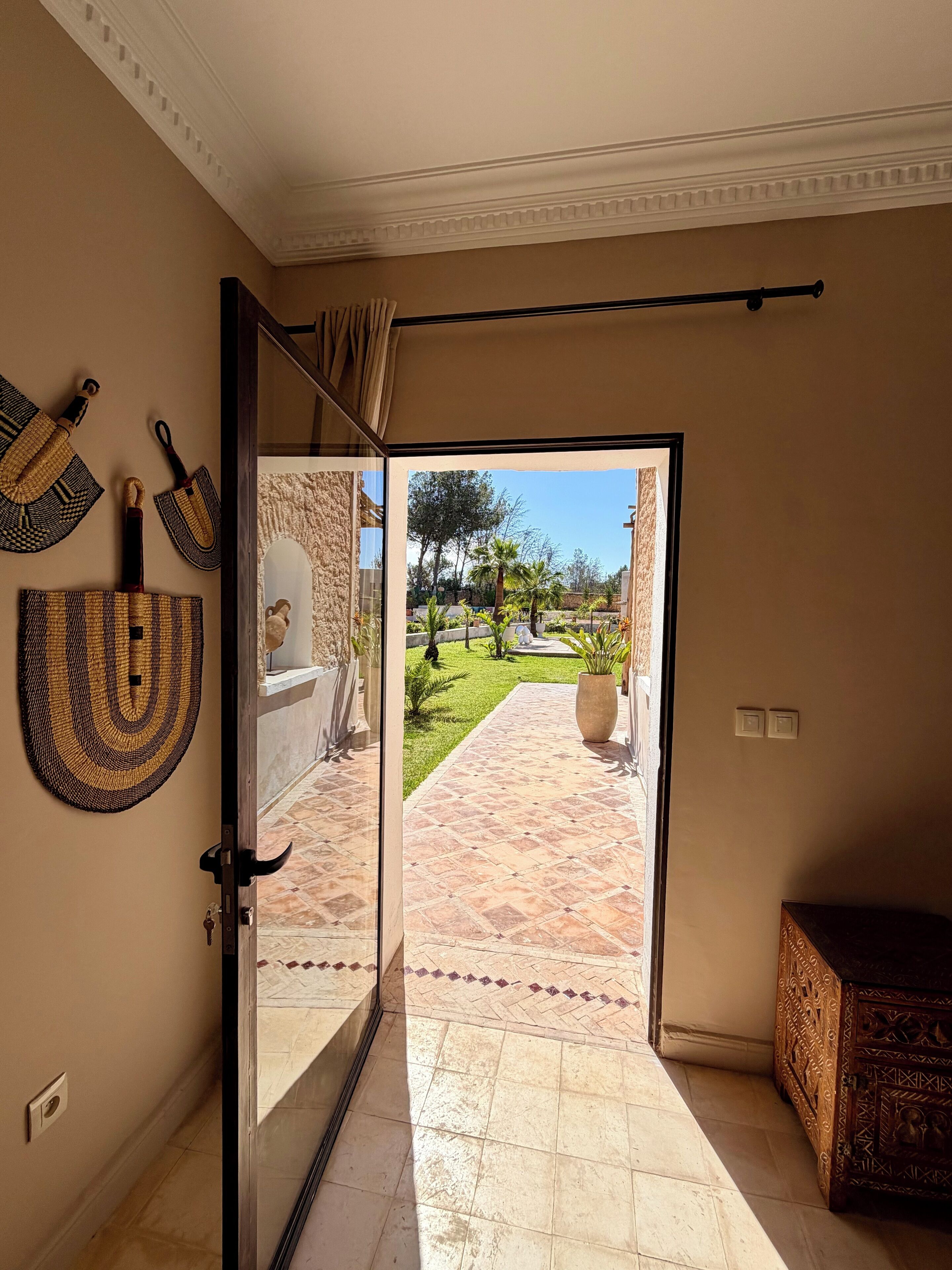 A hallway leading to a patio with a view of a landscaped garden.