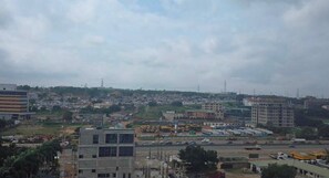 A cityscape with multiple buildings, roads, and construction sites. - Harmonia Residence (Accra)