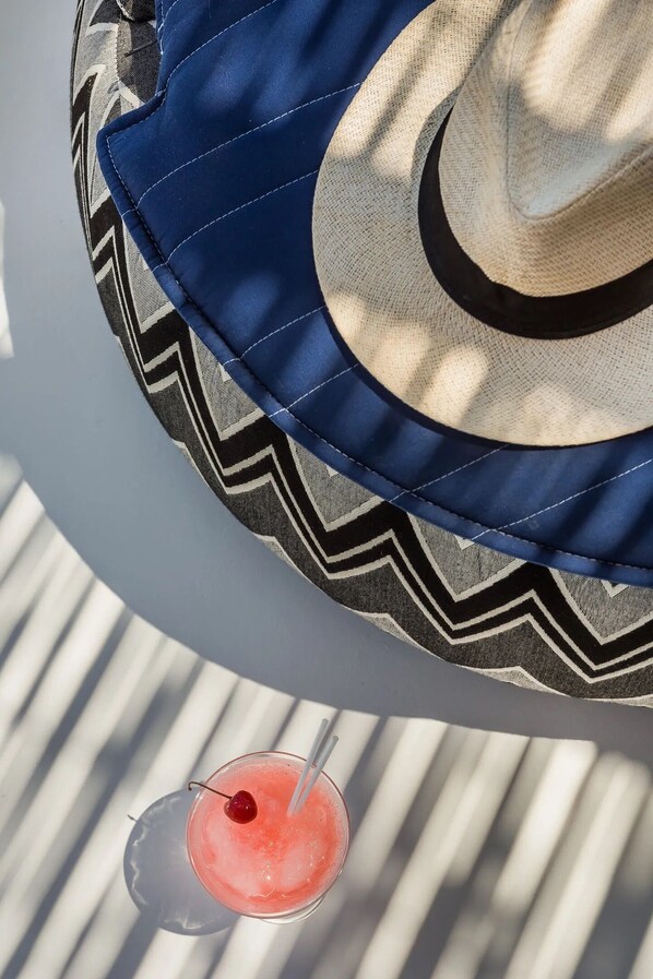 A hat and a drink on a table.