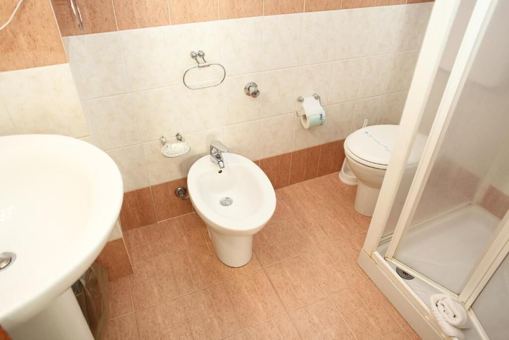 Un baño con bidé, inodoro y lavamanos.
