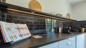 Una cucina moderna con un piano di lavoro scuro, una rivista e una macchina per il caffè.