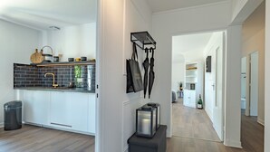 Eine moderne Küche mit weißen Schränken, einer schwarzen Spritzschutzwand und einer Holz Arbeitsplatte.