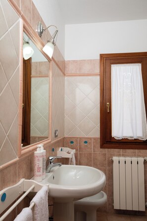 A bathroom with a sink, mirror, and towel rack. - Casa delle Vigne by Wonderful Italy (Olbia)