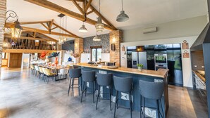 Una cocina amplia con una isla central, taburetes de bar y electrodomésticos modernos.