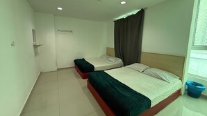A hotel room with two beds, a small table, a mirror, a window with curtains, and a blue laundry basket. - OYO 91288 HOTEL PARADISE BATU CAVES (Selayang)