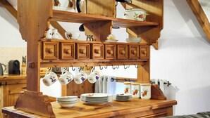 A wooden kitchen with a hanging tea set and stacked plates. - Host & Stay | The Grainary (Bridlington)
