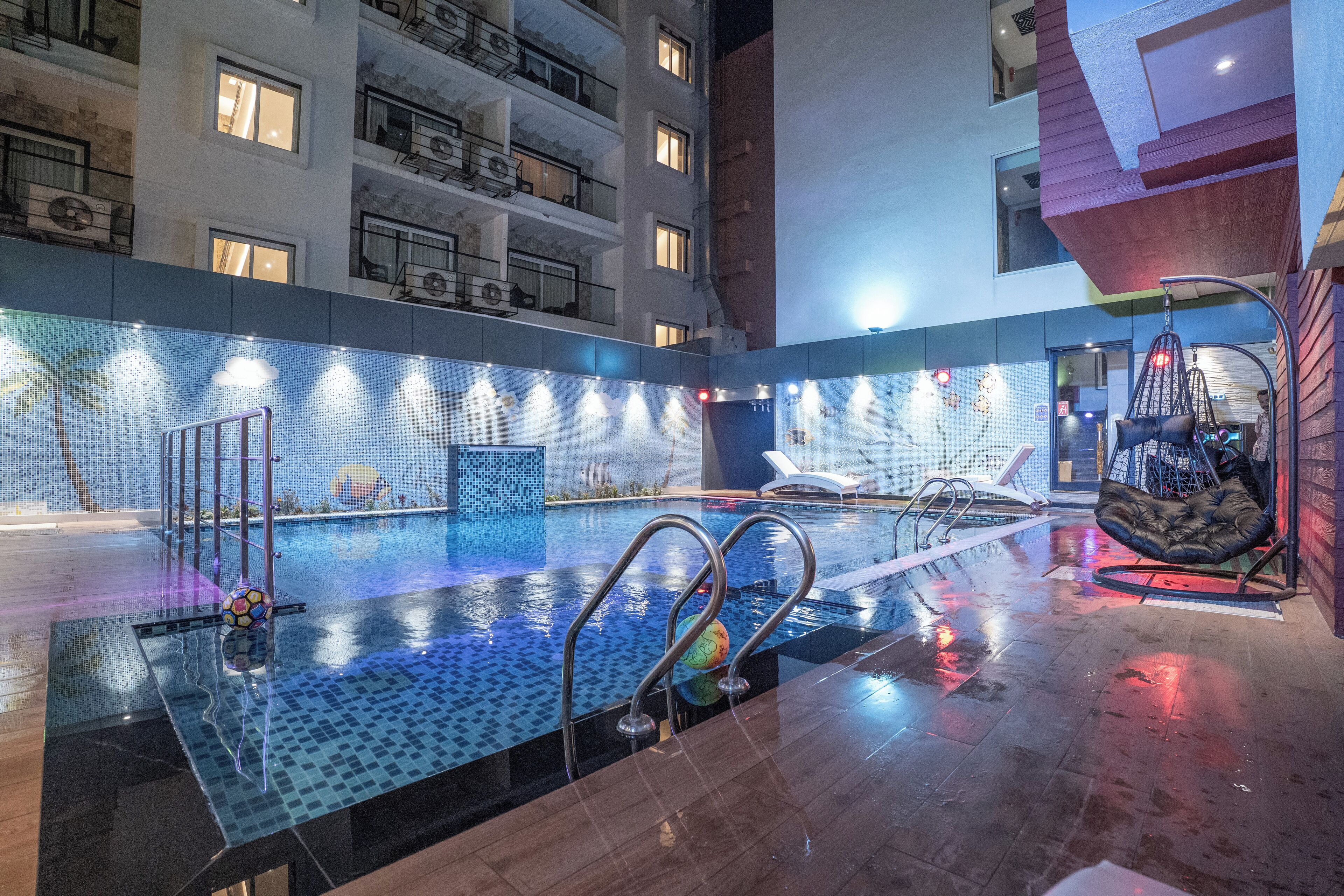 An indoor swimming pool with clear water, metal railings, and a modern design.