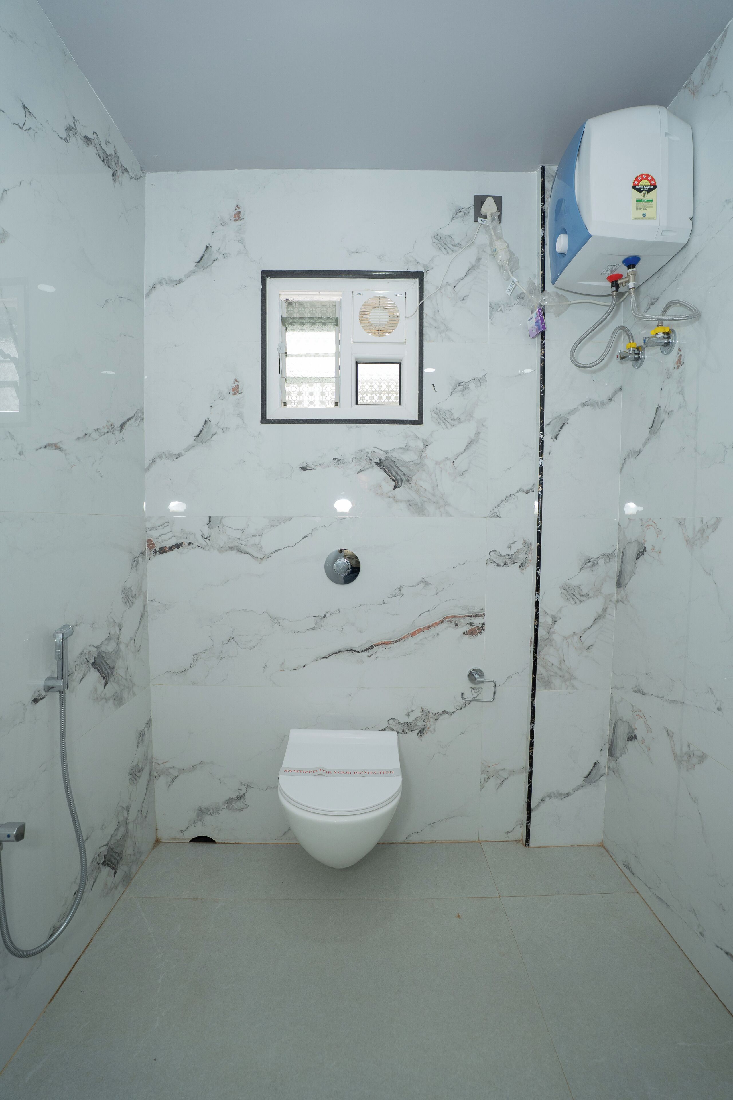 Un baño con inodoro, ducha y calentador de agua.